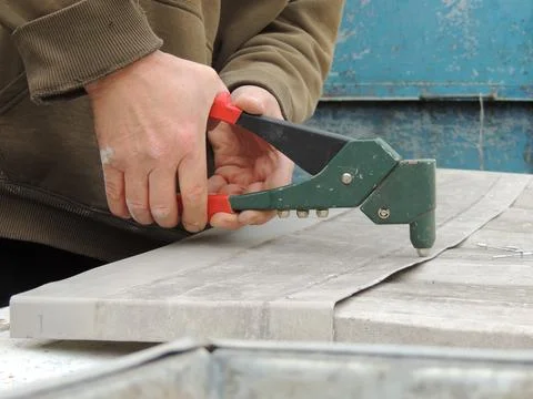 Joining metal elements using a hand riveter Foto stock