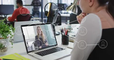 Joining remote call via laptop interface, woman wearing formal attire at desk in Stock Photos