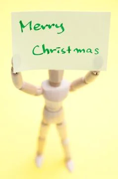 Joint dolls holding yellow notes with Merry Christmas Stock-Fotos