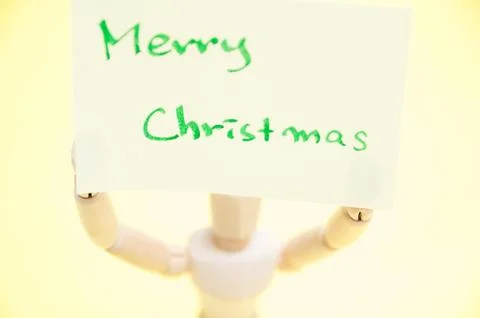 Joint dolls holding yellow notes with Merry Christmas Foto stock