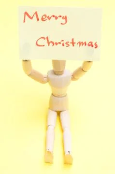Joint dolls holding yellow notes with Merry Christmas Stock Photos