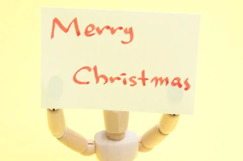 Joint dolls holding yellow notes with Merry Christmas Stock Photos