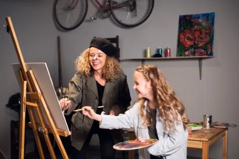 Joint work of two artists. Young funny girls draw a picture in the artist's Foto stock