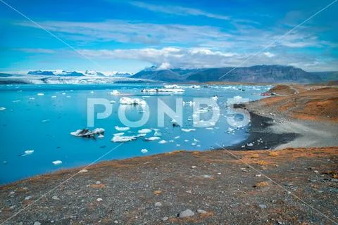 Jokulsarlon lake with icebergs on a sunny day, Iceland. Long exposure view wi Stock Photos