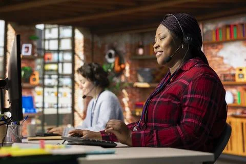 Jolly customer center worker assisting clients needing help resetting password Stock Photos