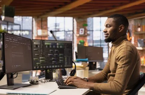 Jolly IT worker using computer in innovative Silicon Valley workplace Stock Photos