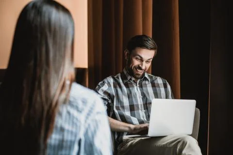 Jolly man is exploiting notebook while relaxing with woman 스톡 사진