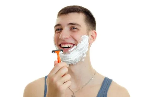 Jolly nice guy with foam beard holds in his hand shaving machine and laughs is Stock Photos