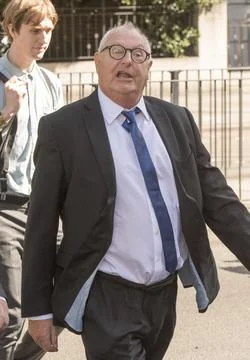 Jonathan King, 72, waves as he enters court to face 18 historical sex offence ch Stock Photos
