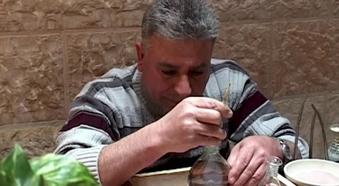 Jordan, Petra. Master pours sand into glass Souvenir bottle. Stock Footage 150940436