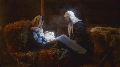 Joseph talking with Mary and baby Jesus in barn Stock Footage
