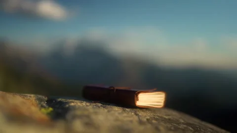 Journal sitting on rock with mountain backdrop, rack focus Stock Footage 207611370