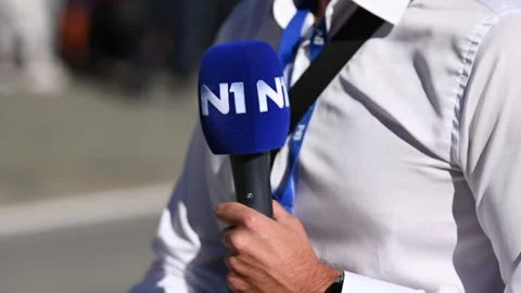 Journalist holding microphone while reporting to a live program. Stock Footage 315069049