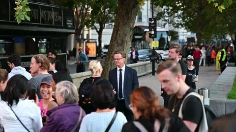 A journalist interviewing people queuing on the South Bank of the River Thames Stock Footage 210832204
