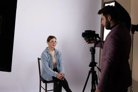 A journalist is interviewing a person in a studio setting. Stock Photos
