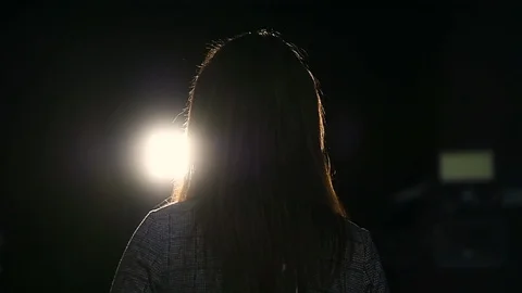 Journalist making a live broadcast in front of a spotlight 스톡 동영상 119985078