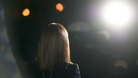 Journalist making a live broadcast in front of a spotlight Video stock 119985136