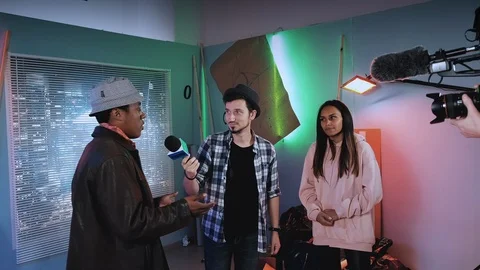 Journalist taking interview for yellow media with black actors of the new film Stock Footage 124337580