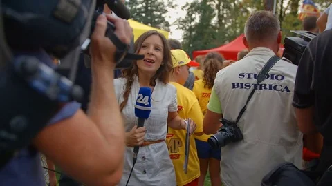 Journalist is walking in the crowd and is talking about the motorcross event Video stock 74656436