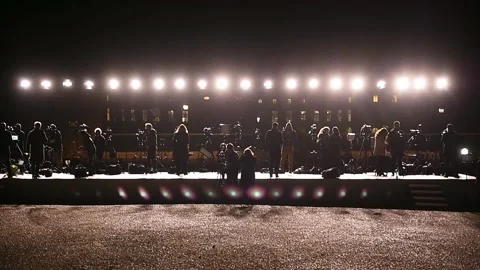 Journalists making a live broadcast on a large scene in front of spotlights 스톡 동영상 172020174