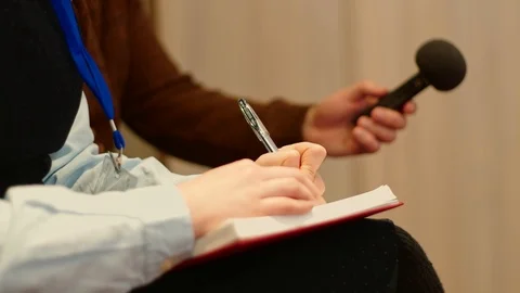 Journalists at the press conference make notes in a notebook and audio recording Stock Footage 101795682