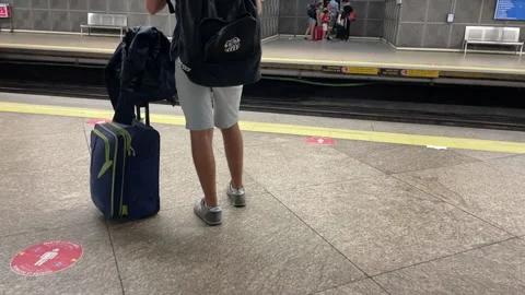 Joven esperando el metro con maletas Stock Footage 162543325