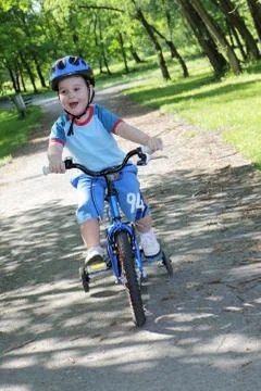 Joy game on child bicycle in spring in park Stock Photos