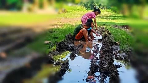 The joy of three small children playing with water and mud. Stock Photos