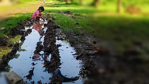 The joy of three small children playing with water and mud. Stock Photos