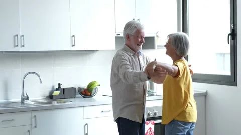 Joyful active old retired romantic couple dancing laughing in living room, happy Stock Footage 237939252