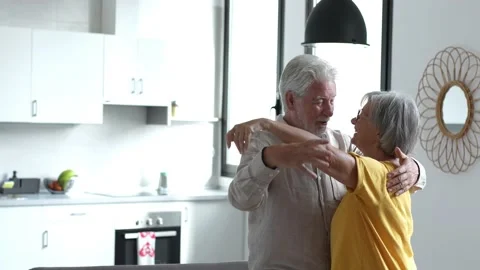 Joyful active old retired romantic couple dancing laughing in living room, happy Stock Footage 237939570