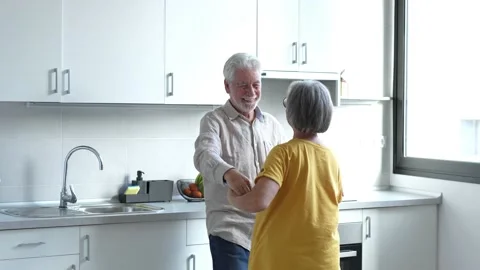 Joyful active old retired romantic couple dancing laughing in living room, happy Stock Footage 237940187