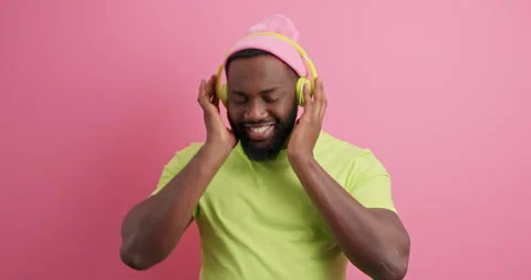 Joyful bearded dark skinned man moves with rthythm of music wears stereo Stock Footage 149918098