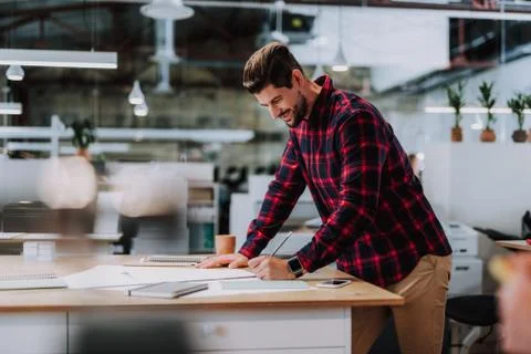 Joyful bearded engineer making a drawign in the office Stock Photos