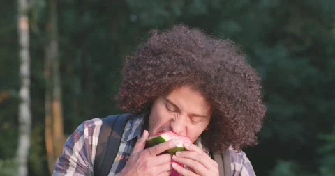 Joyful Bite: North African Man Enjoying Watermelon in slow motion Stock Footage 256025094