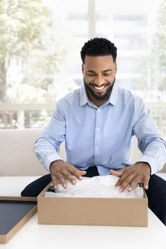 Joyful Black client man getting parcel from transportation logistic service 스톡 사진