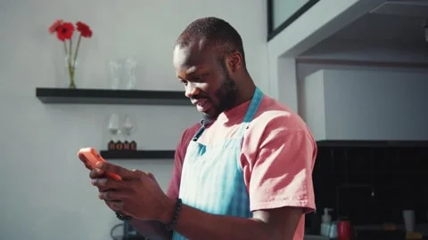 Joyful black young handsome man receiving unexpected news on smartphone Stock Footage 131669626