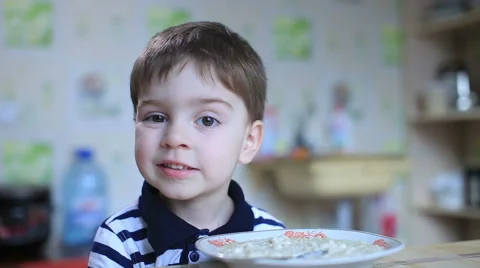 Joyful boy eats in the kitchen Stock-Footage 57749867