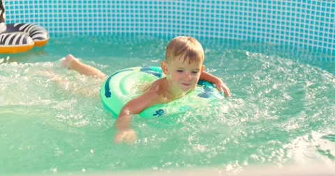 Joyful boy jumping into the pool in the backyard enjoying his summer vacation Stock Footage 254280418