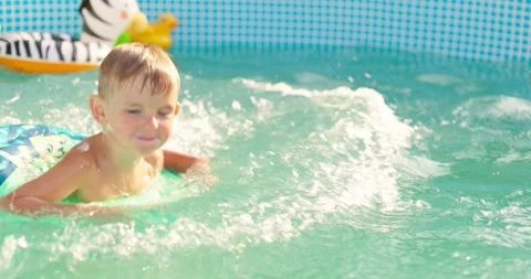 Joyful boy jumping into the pool in the backyard enjoying his summer vacation Stock Footage 254424666