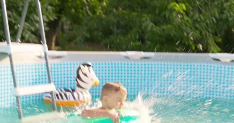 Joyful boy jumping into the pool in the backyard enjoying his summer vacation Stock Footage 255307847