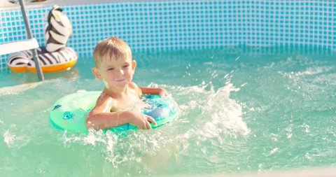 Joyful boy jumping into the pool in the backyard enjoying his summer vacation Stock Footage 255662111