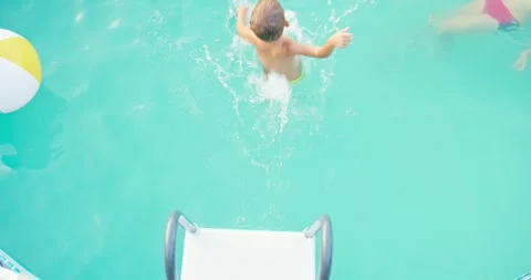 Joyful boy jumping into pool, enjoy swimming in pool, enjoying summer vacation Stock Footage 255307697