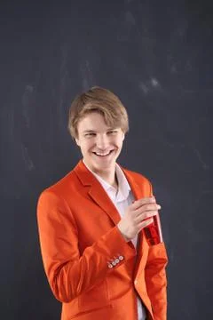 Joyful boy in orange jacket with a cup of coffee  Stock Photos