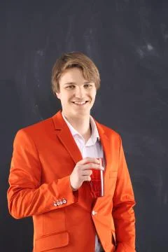 Joyful boy in orange jacket with a cup of coffee  Stock Photos