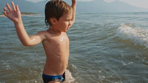 Joyful boy playing with the sea waves Stock-Footage 104920103
