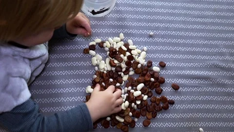 Joyful boy plays with beans and beans. Stock Footage 220619944