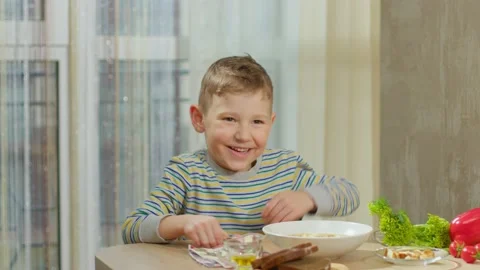 A joyful boy runs up to the table where lunch is waiting for him. Video stock 235724348