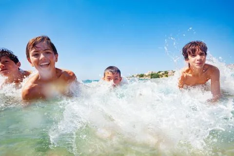 Joyful boys having fun while swimming in the sea Stock Photos