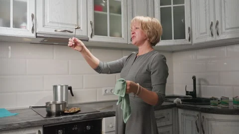 Joyful Cake Decorator Singing While Observing Golden Bell in Bright Kitchen Stock Footage 307991848